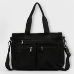 Sac cabas Aveline noir en toile, anses hautes et bandoulière, poches zippées.
