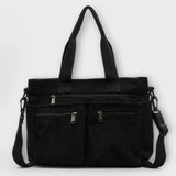 Sac cabas Aveline noir en toile, anses hautes et bandoulière, poches zippées.