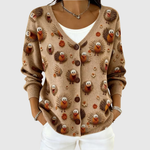 Cardigan en tricot beige à boutons, motifs d’animaux colorés, manches longues côtelées.