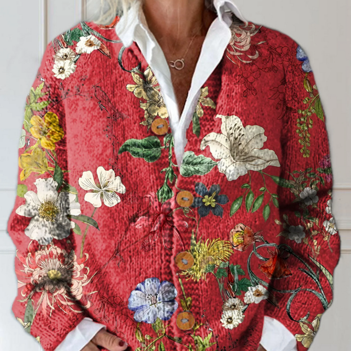 Cardigan tricoté rouge à col ouvert, boutons et motifs floraux vintage multicolores.