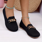 Chaussures plates noires avec lanière décorative chaîne dorée sur le dessus.