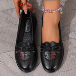 Mocassins noirs à nœud, détail floral en relief sur le dessus, semelle crantée.