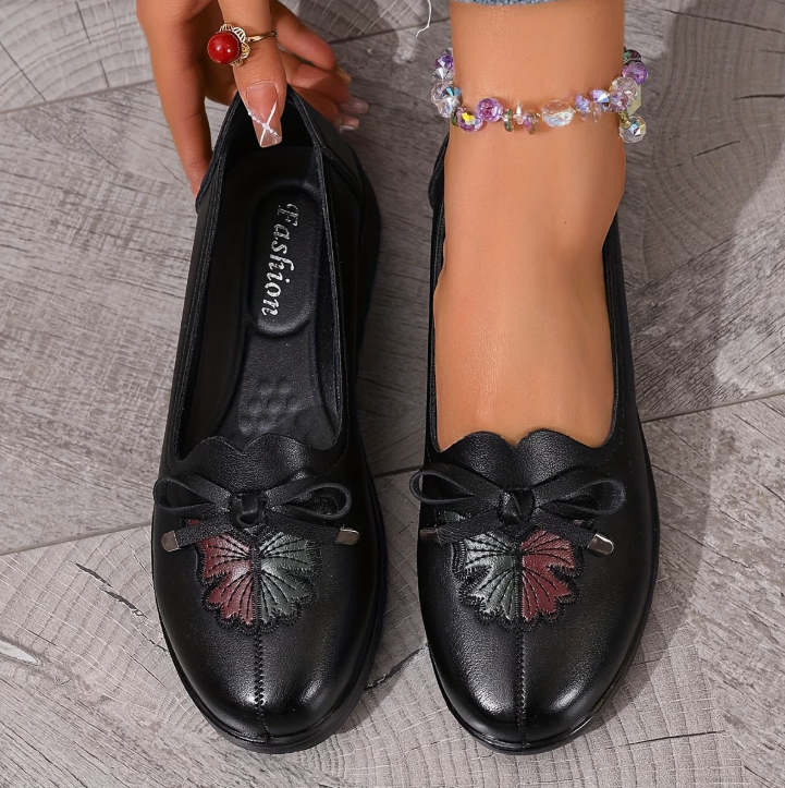 Mocassins noirs à nœud, détail floral en relief sur le dessus, semelle crantée.