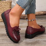 Mocassins bordeaux à nœud, semelle crantée, empiècement floral en relief sur le dessus.