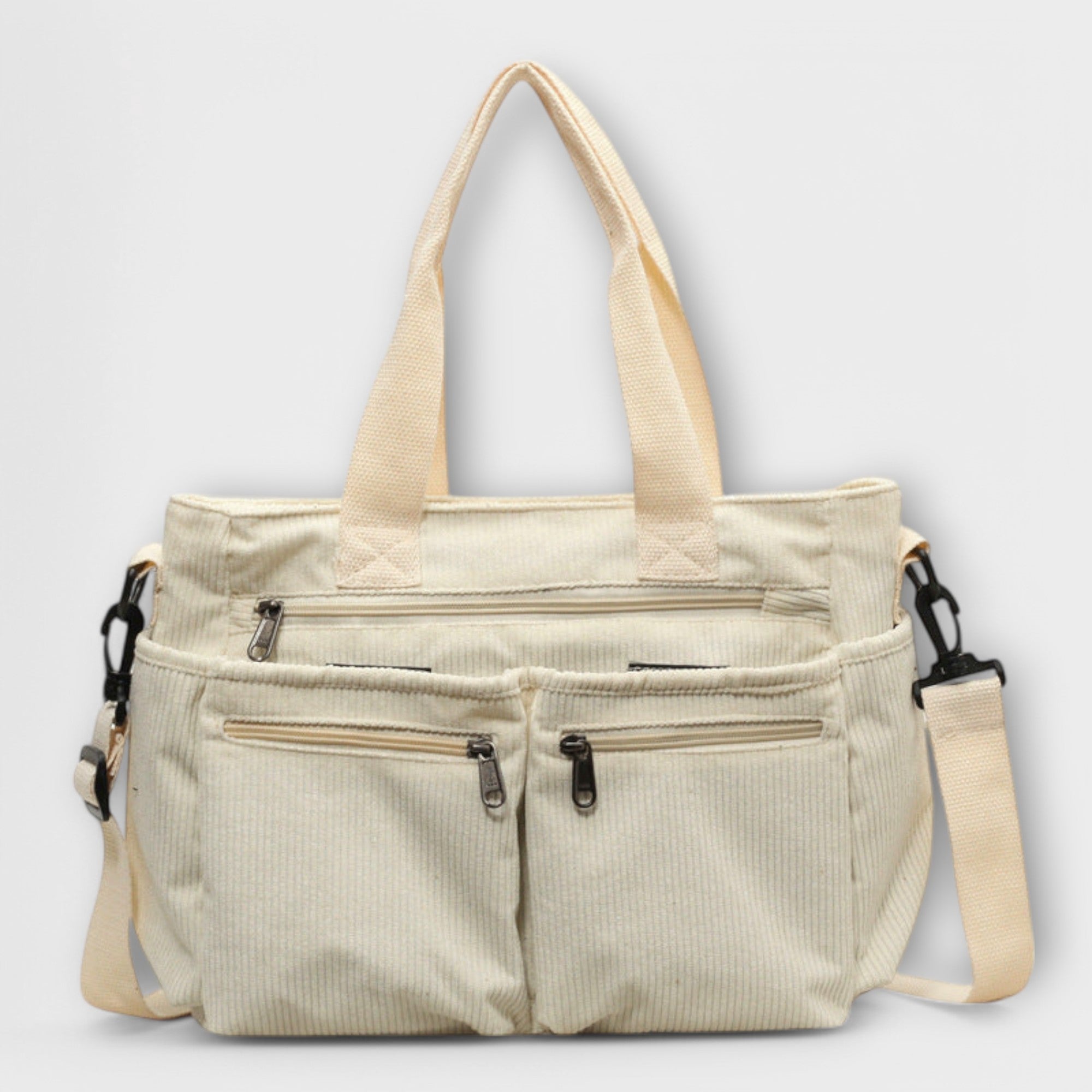 Sac cabas Aveline beige en toile, bandoulière et poches zippées sur le devant.