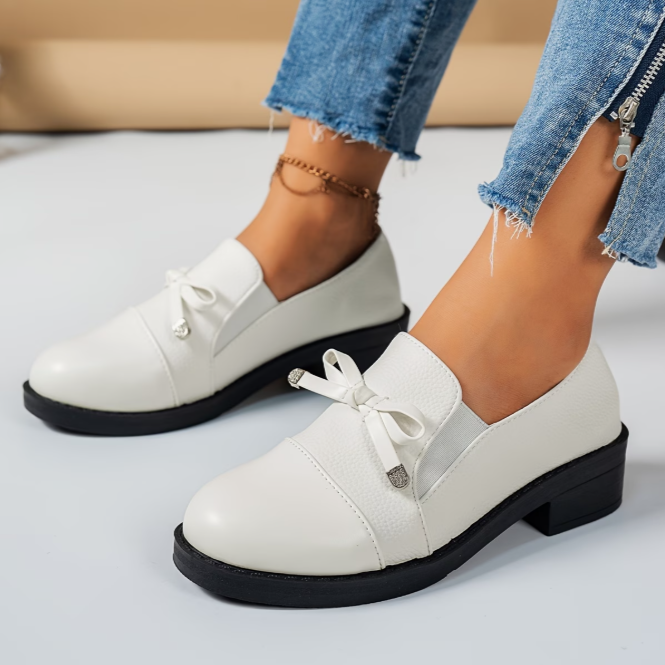 Mocassins blancs à talon bas, nœud décoratif et boucle, dessus en cuir texturé