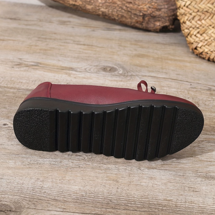 Semelle extérieure noire crantée de mocassin bordeaux, vue de dessous.
