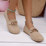 Chaussures plates beiges avec chaîne dorée décorative sur l’avant.