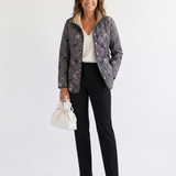 Veste matelassée à imprimé floral vintage, fond sombre, col chaud, fermeture boutonnée.