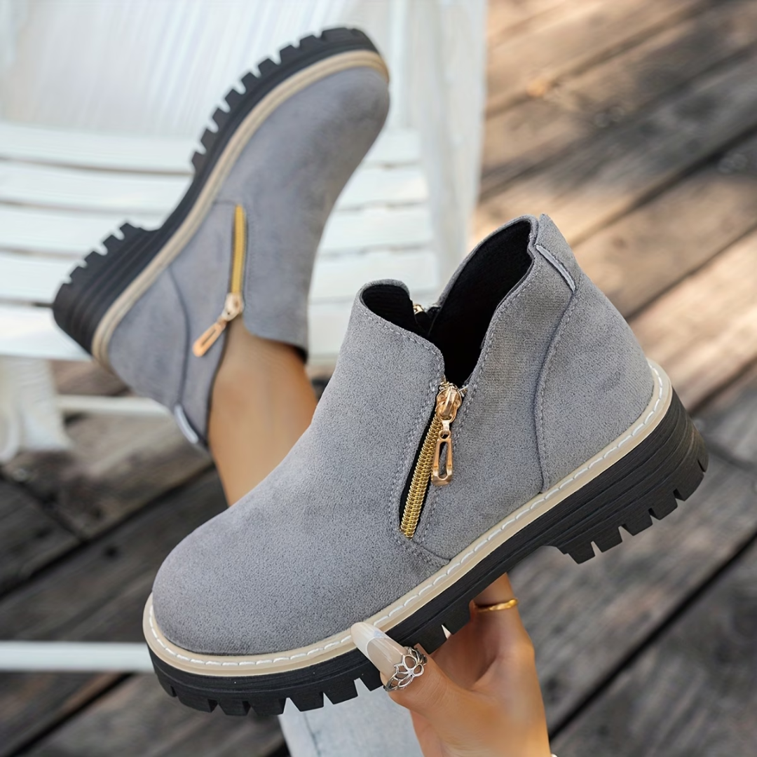 Bottines grises suédées à double zip doré et semelle crantée, bord blanc.