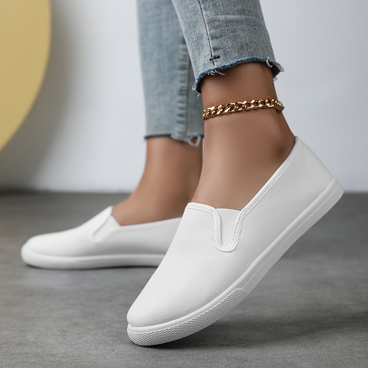 Chaussures souples à enfiler blanches, chaînette dorée à la cheville, profil latéral.