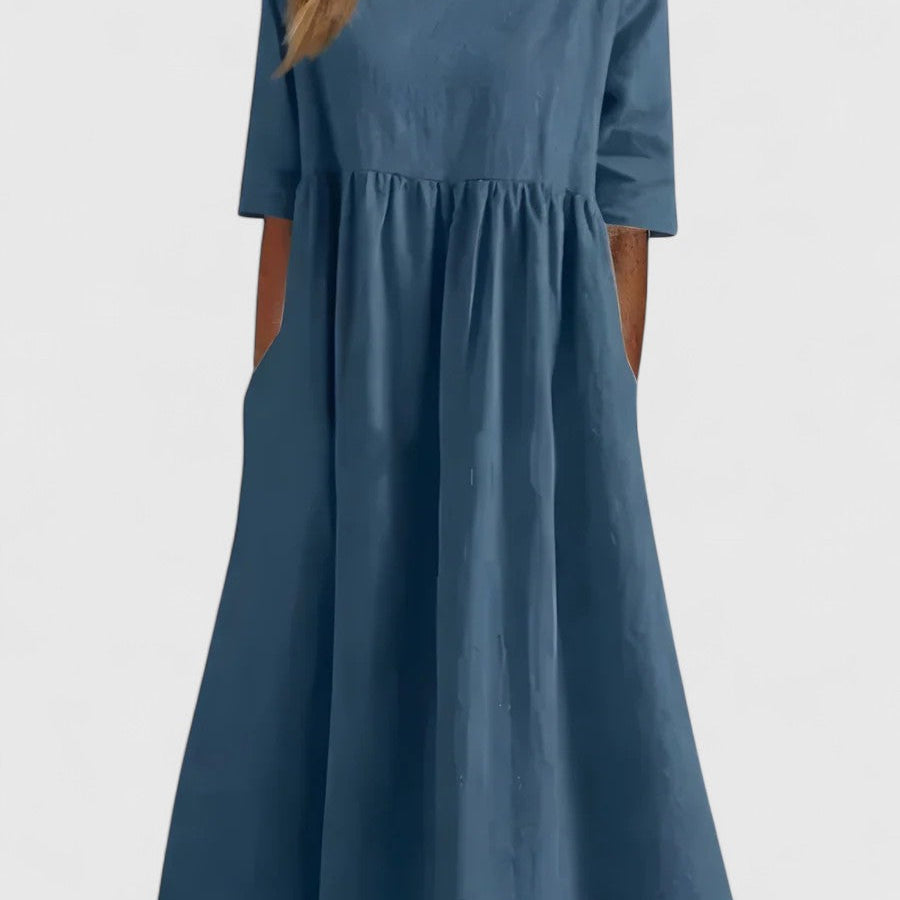 Robe mi-longue bleue à manches courtes, encolure carrée et taille froncée.