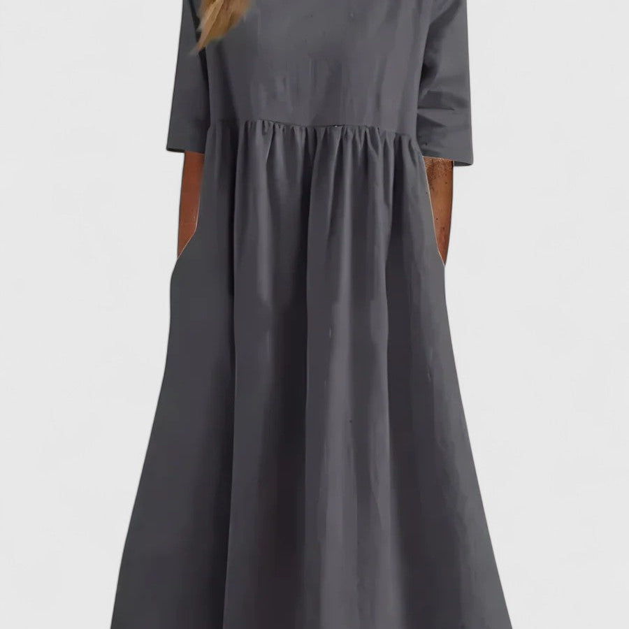 Robe mi-longue gris foncé à manches courtes, encolure carrée et taille froncée.