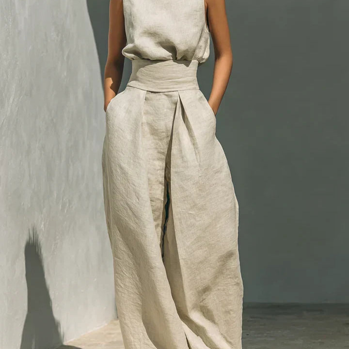 Ensemble femme en lin beige clair, haut col montant sans manches et pantalon large à plis.