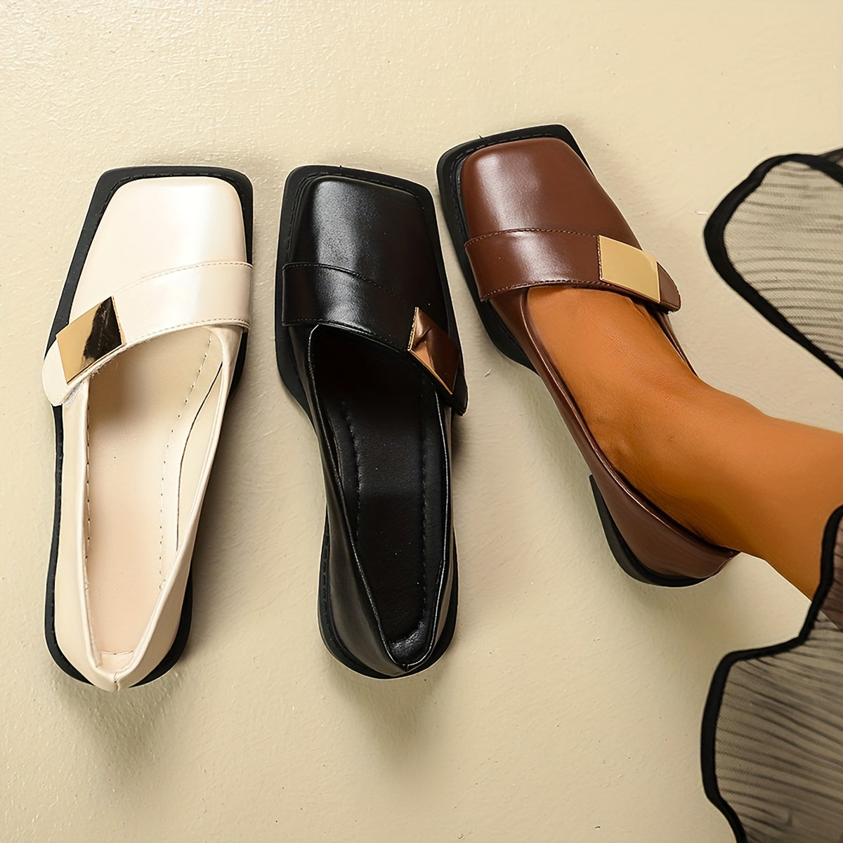 Mocassins bicolores assortis : blanc, noir et marron, brides carrées, semelles noires.