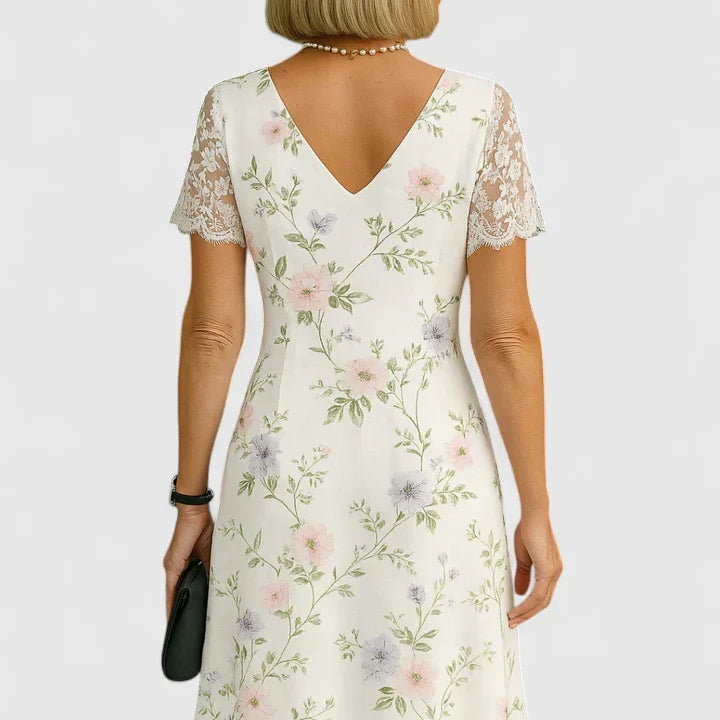 Robe midi blanche à fleurs pastel, dos échancré en V et manches courtes en dentelle.