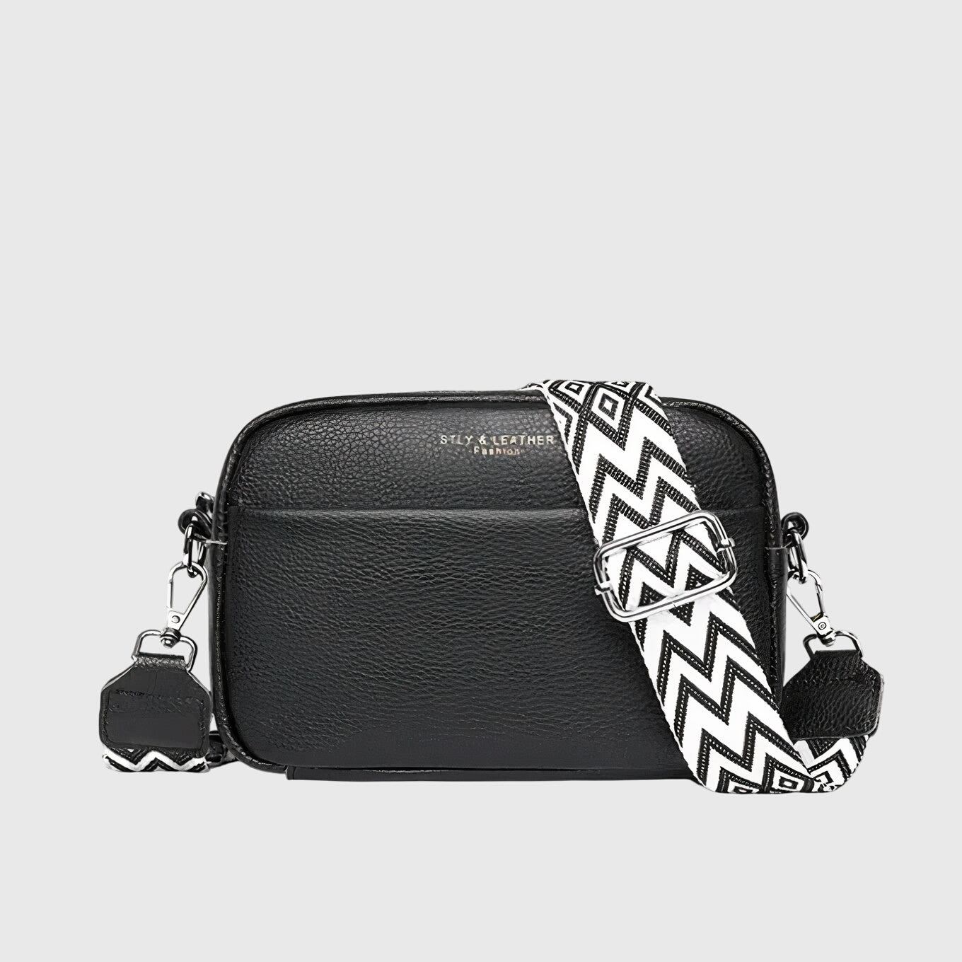 Sac à bandoulière en cuir noir, fermeture zippée, bandoulière à motif zigzag.