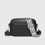 Sac à bandoulière en cuir noir, fermeture zippée, bandoulière à motif zigzag.