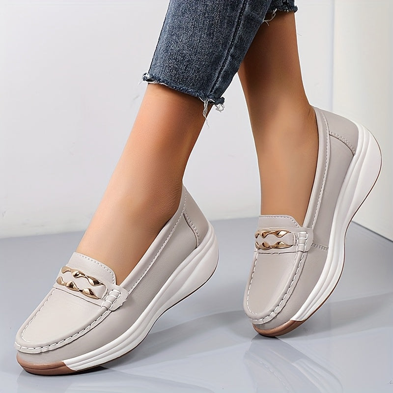 Mocassins gris clair/beige à bout rond, semelle blanche épaisse, bride décorative dorée.