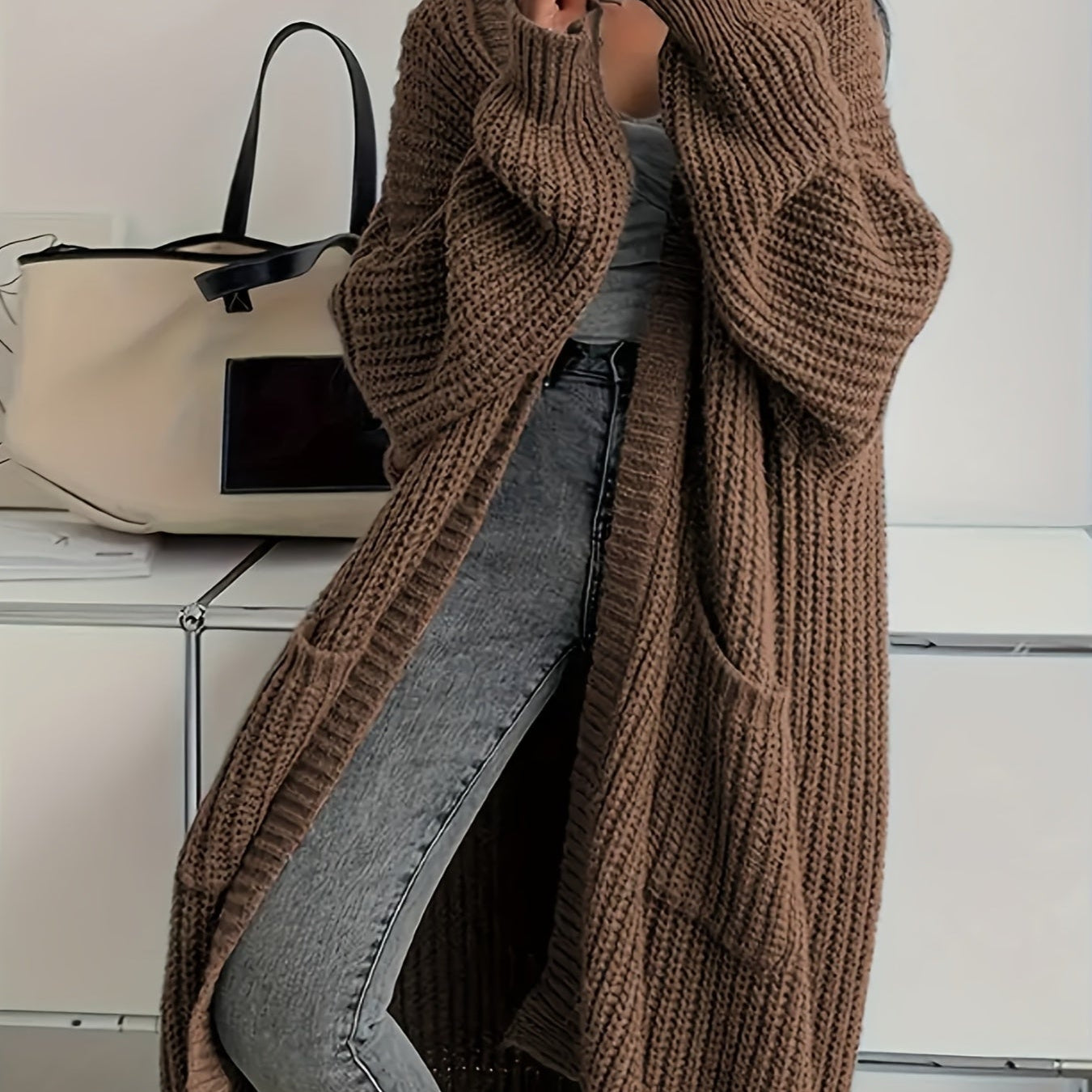 Cardigan long en maille côtelée marron foncé, manches longues, devant ouvert.