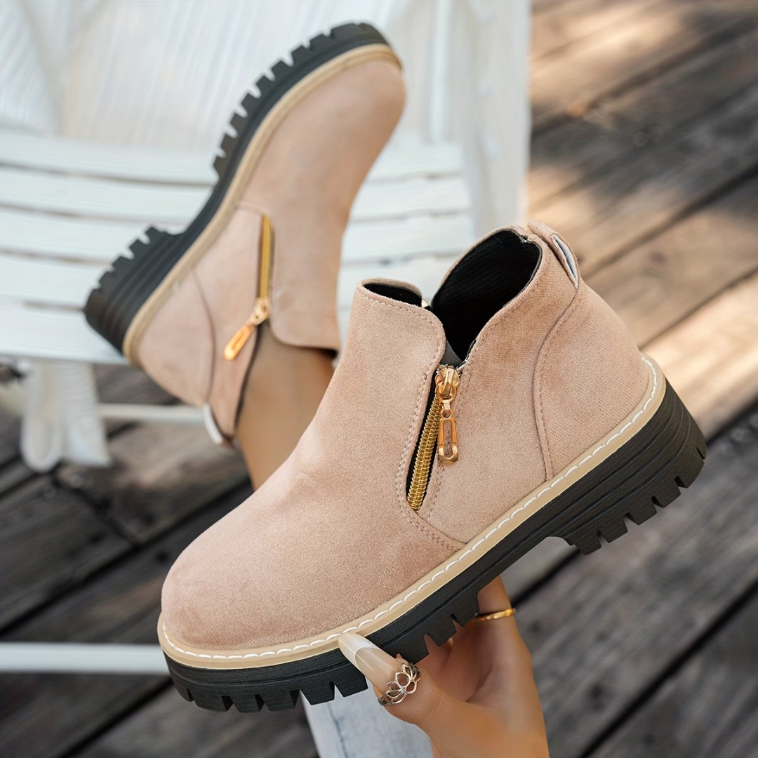 Bottines beige rosé en suédine, double zip doré et semelle crantée noire.