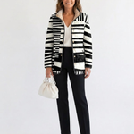 Veste matelassée à motifs abstraits noir et blanc, manches longues, fermeture boutonnée.