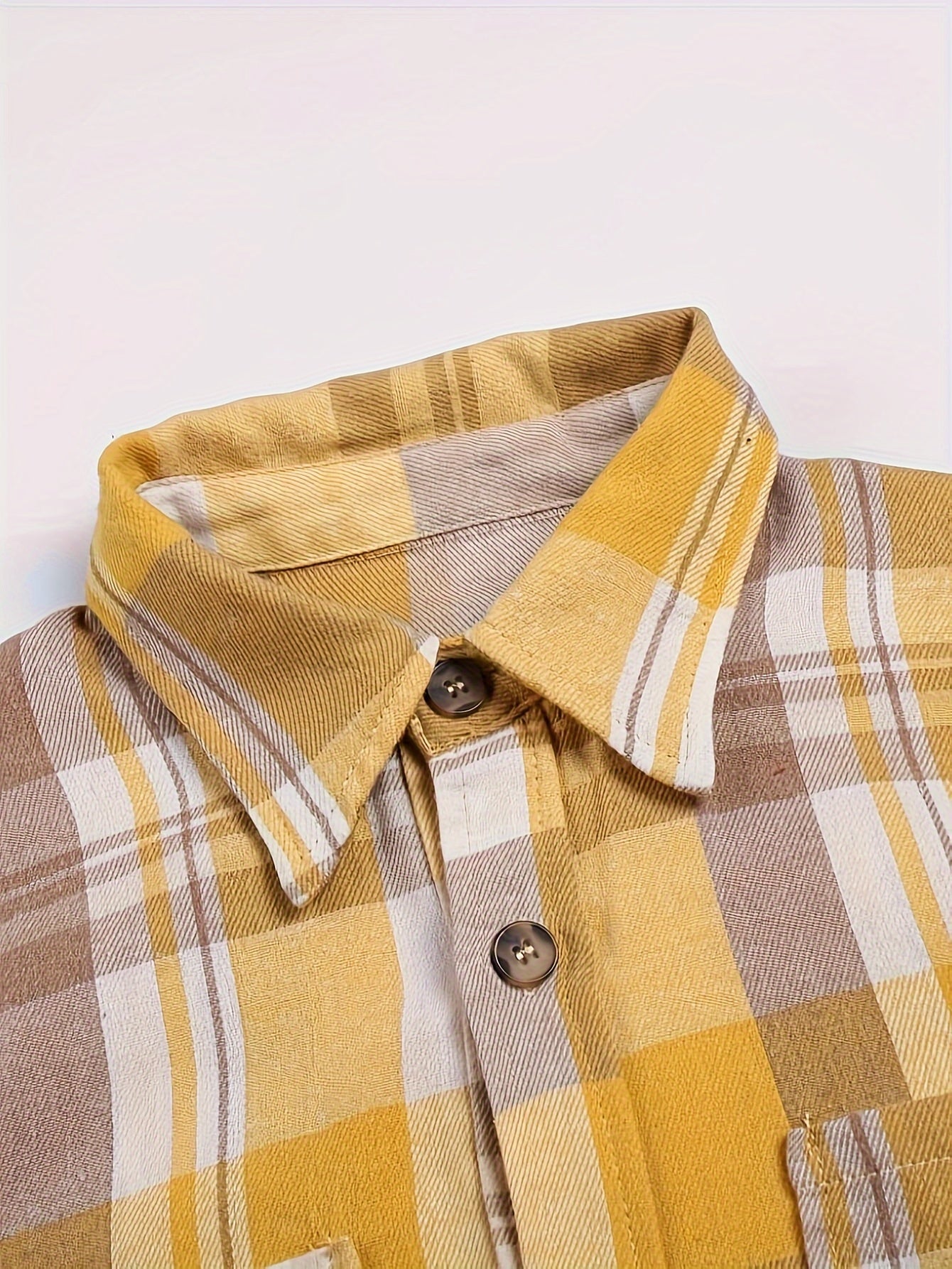 Chemise à carreaux jaunes détail du col et des boutons, manches longues.