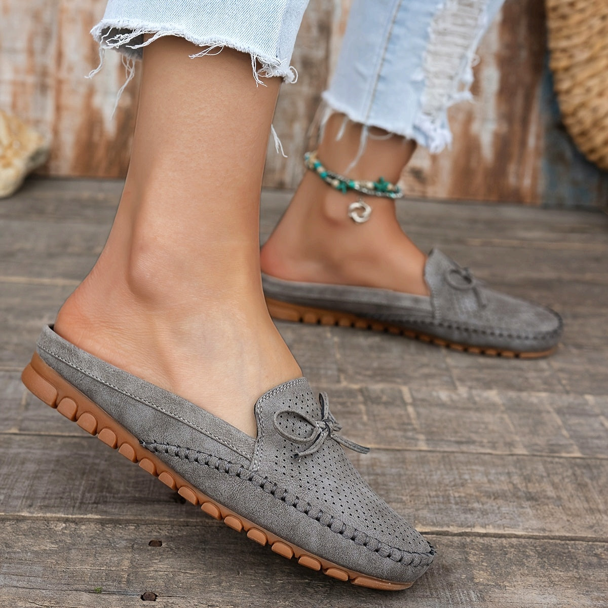 Sabots mocassin en daim gris, mocassin perforé et nœud au bout, semelle piquée.