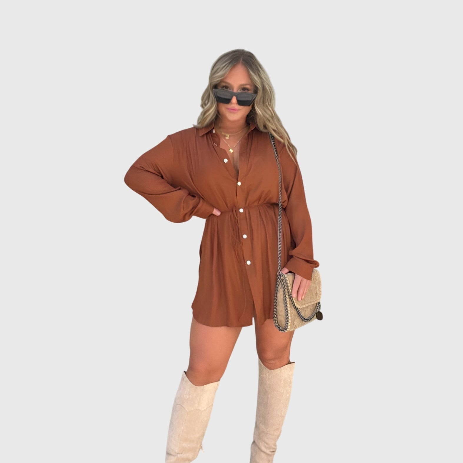 Robe salopette courte à manches longues boutonnées, lien à la taille, couleur brun foncé.