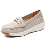 Mocassins beige clair à bout rond, semelle blanche épaisse, bride décorative dorée.