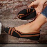 Ballerines souples respirantes noires à rayures orange, portées avec talon compensé.