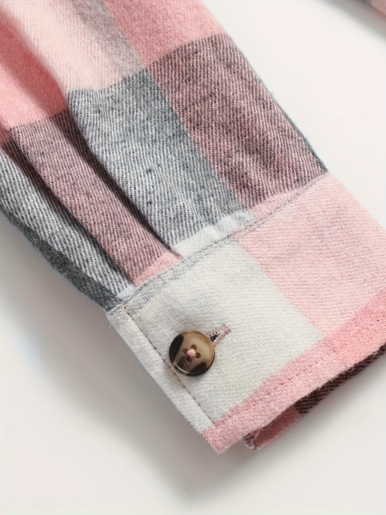 Chemise à carreaux rose et gris, bas de manche avec bouton et surpiqûres.