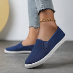 Chaussures souples à enfiler bleu nuit, chaînette dorée à la cheville, semelle blanche.