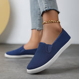 Chaussures souples à enfiler bleu nuit, chaînette dorée à la cheville, semelle blanche.