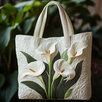 Sac matelassé blanc à arums blancs et feuilles vertes, anses en tissu.
