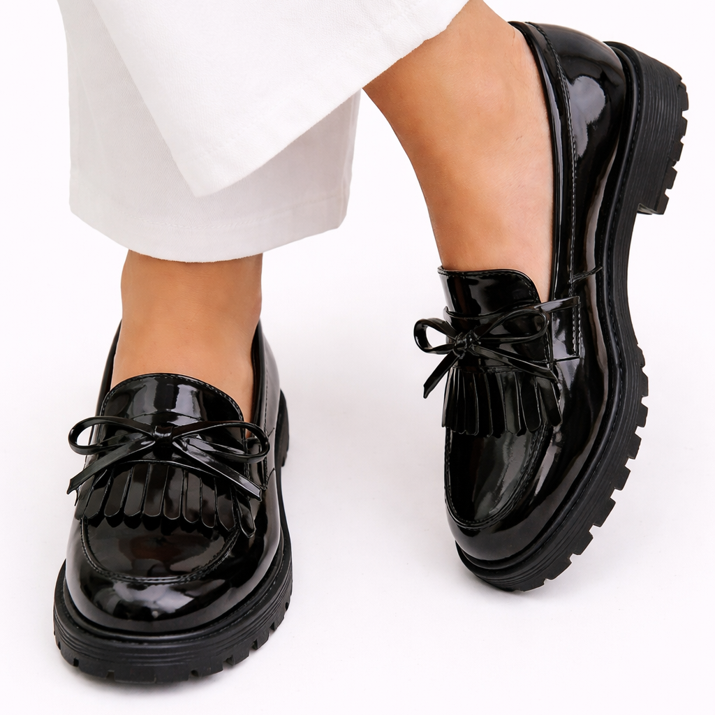 Chaussures vernies noires à nœud, semelle crantée et franges visibles