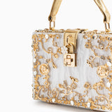 Sac rectangulaire blanc à motifs dorés, fermoir carré central et poignées dorées