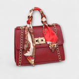 Sac à main bordeaux avec foulard imprimé, rabat, fermoir rectangulaire, chaîne dorée.