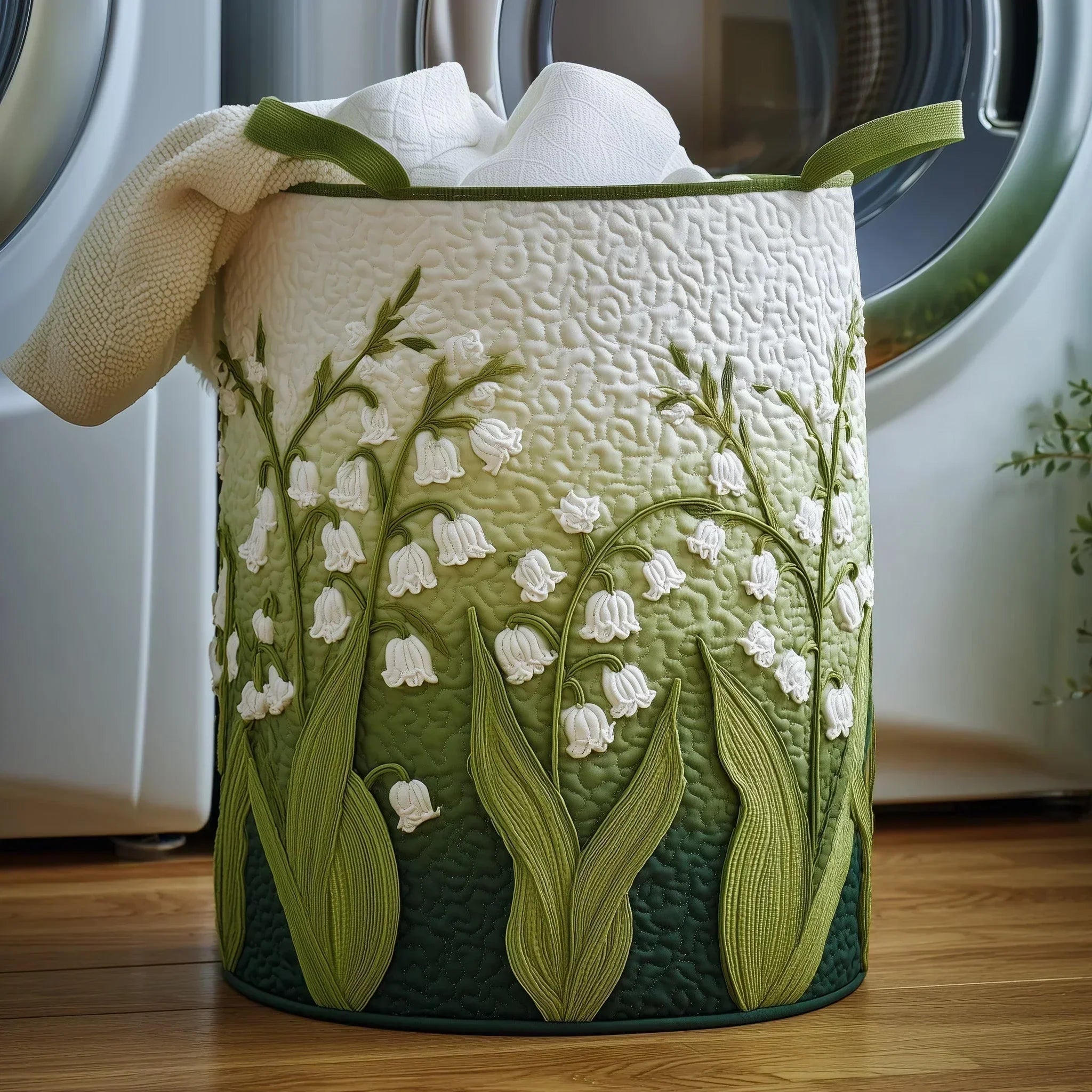 Panier à linge en tissu vert brodé de fleurs blanches