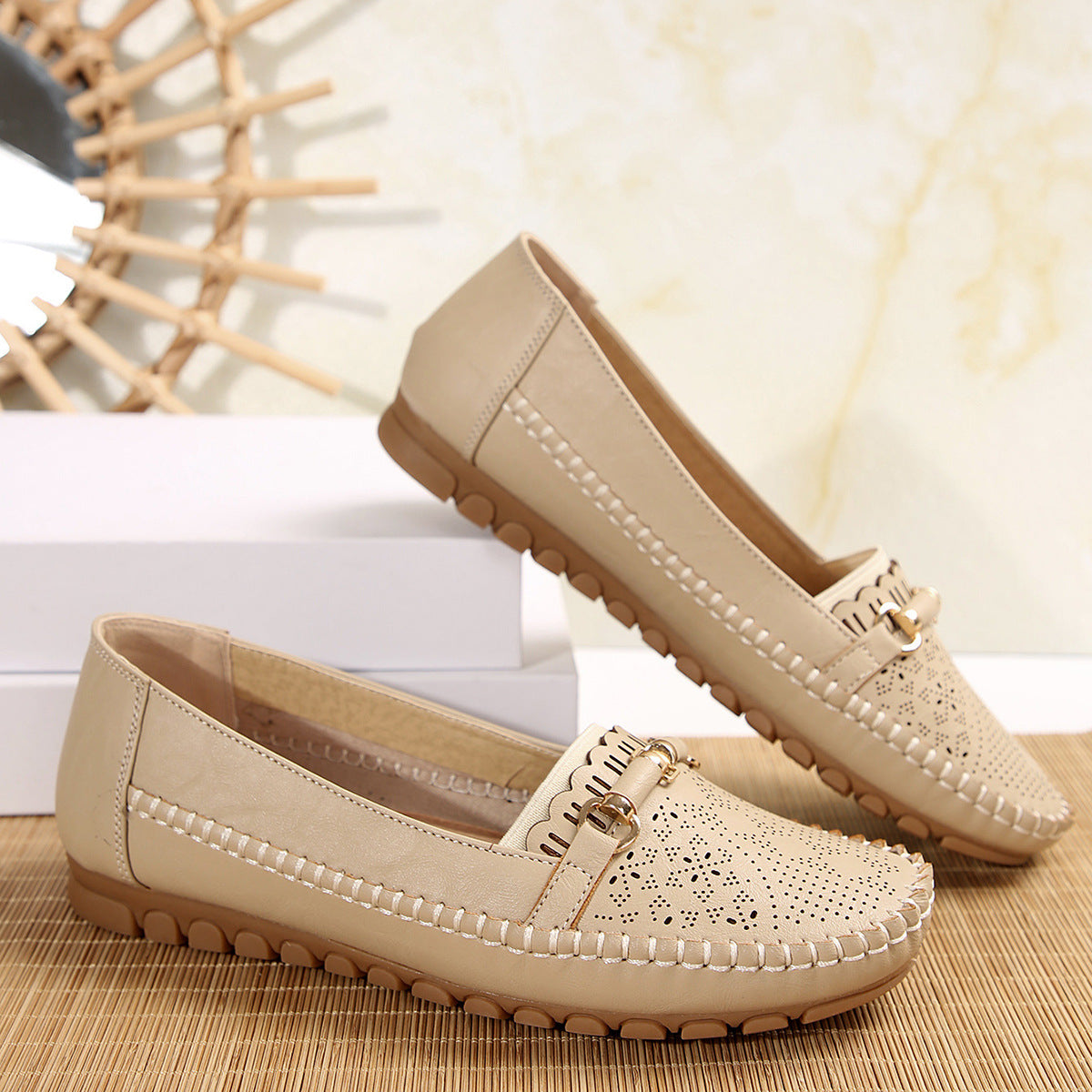 Mocassins beige à bride bouclée, perforations et semelle crantée en gomme