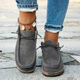 Mocassins gris foncé, style suédé, coutures apparentes et semelle marron