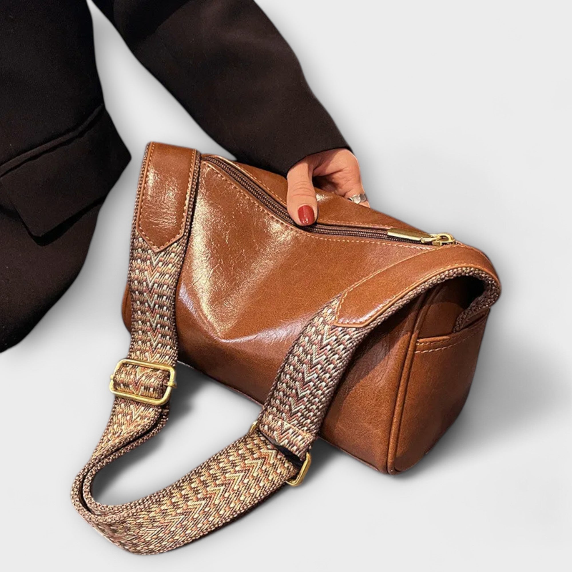 Sac bandoulière vintage en cuir brun caramel, bandoulière tressée et boucle dorée.