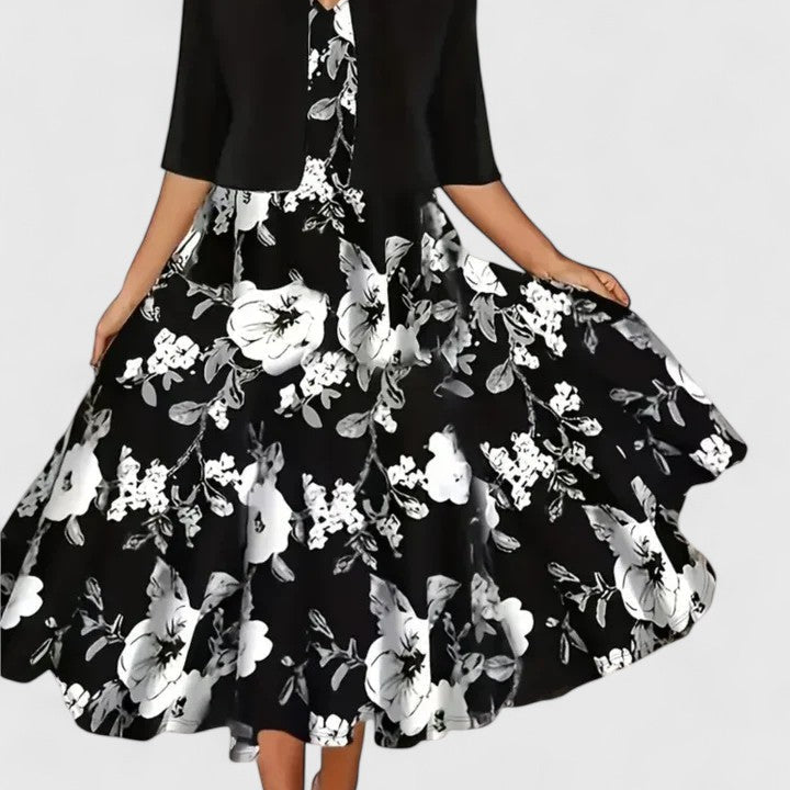 Robe midi noire à motif fleurs et feuillages blancs, manches trois-quarts, jupe évasée