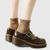 Chaussures bébé en cuir marron à plateforme, bride à boucle et tige courte.