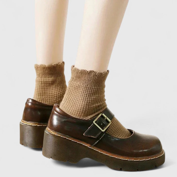 Chaussures bébé en cuir marron à plateforme, bride à boucle et tige courte.