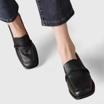 Mocassins à bout carré noirs, vue trois-quarts, bride au dessus et coutures discrètes.