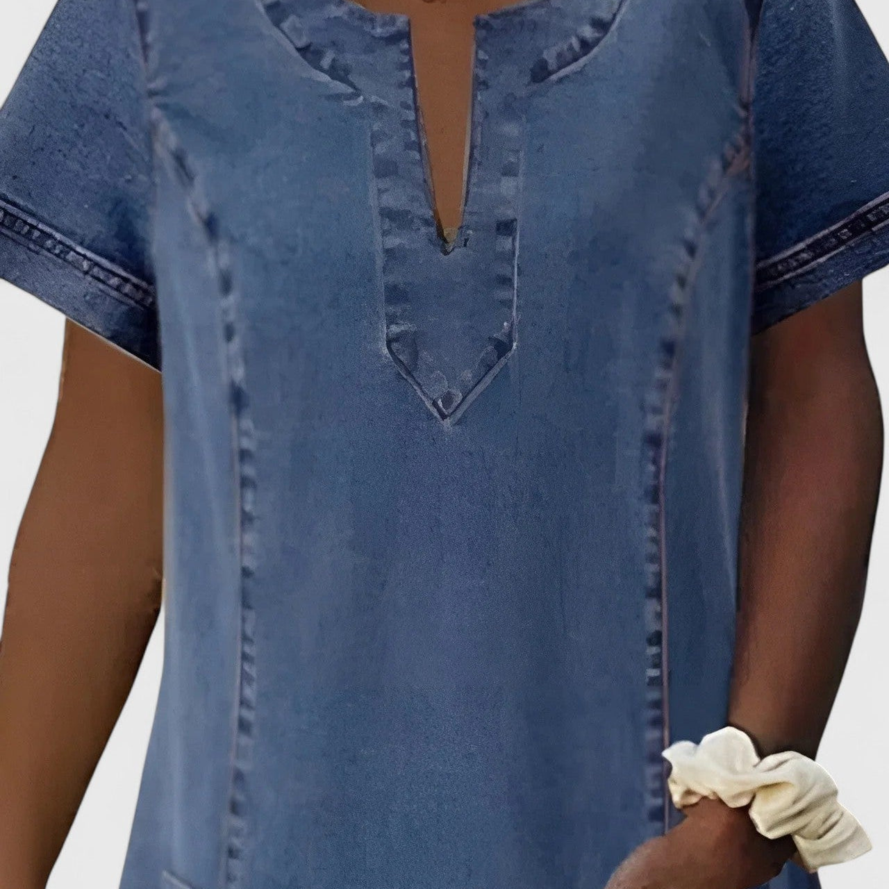 Robe en jean bleue, encolure V, poches poitrine, surpiqûres, manches courtes.