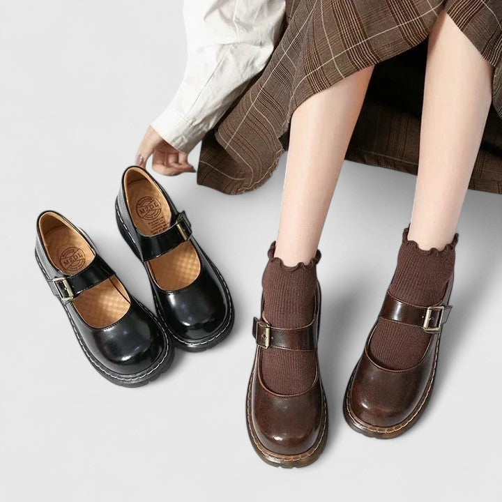 Chaussures bébé en cuir noir et marron, brides à boucle et semelle plateforme épaisse.