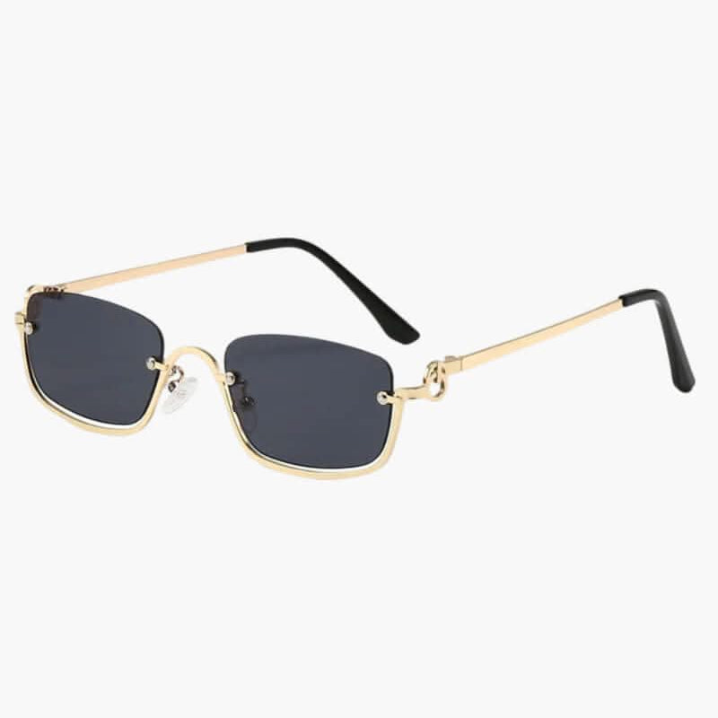 Lunettes de soleil modernes à monture dorée et verres foncés, forme légèrement cat-eye.