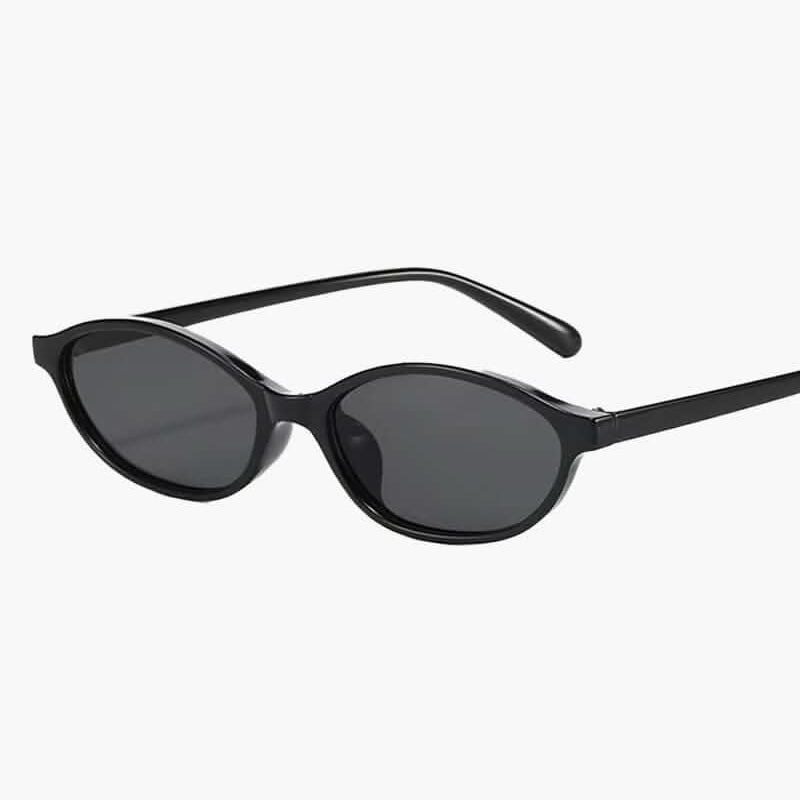 Lunettes de soleil noires à monture fine et verres foncés ovales.